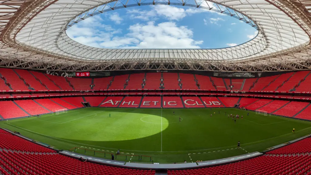 Estadio San Mamés del Athletic Club iluminado en partido nocturno con afición vibrante