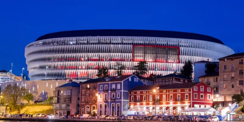 Estadio San Mamés exterior al atardecer con banderas vascas