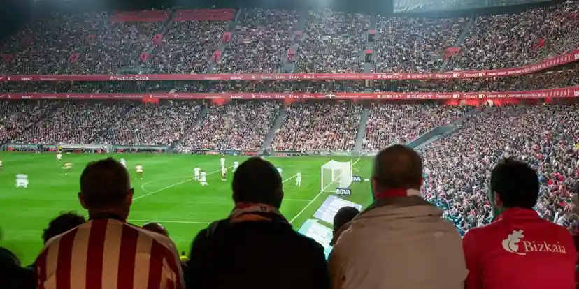 Interior del estadio San Mamés durante partido nocturno con aficionados del Athletic Club